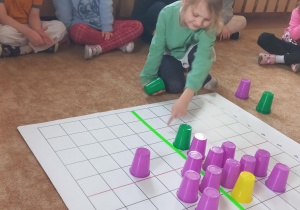 Dziewczynka koduje wiosennego kwiatka.