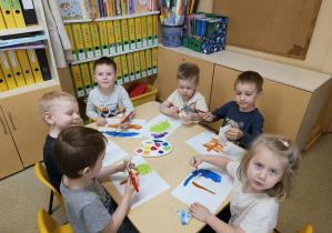Dzieci malują farbami.