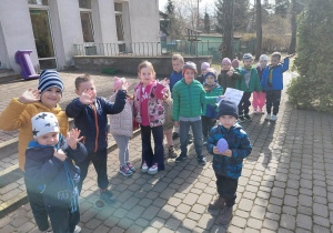 Dzieci spacerują po ogrodzie przedszkolnym.