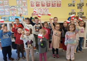 Zdjęcie grupowe z wykonanymi przez dzieci flagami Polski.