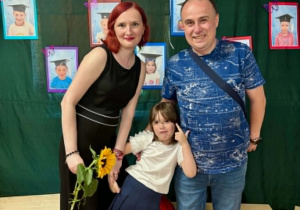 Rodzice i dziewczynka pozują do zdjęcia.