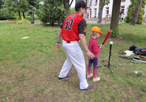 Dziewczynka uczy się gry w baseball.