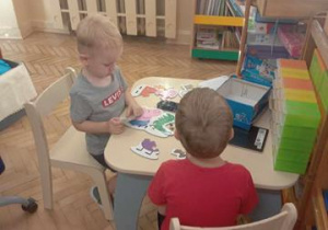 Chłopcy wspólnie układają puzzle.