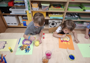 Dzieci rozdmuchują farby.