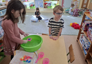 Dziewczynka łowi plastikowe rybki.