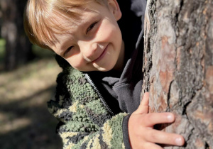 Chłopiec pozuje w lesie.