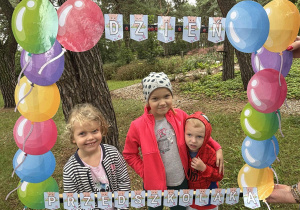 Dzieci pozują do zdjęcia z użyciem fotobudki.