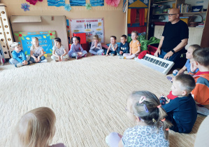 Dzieci biorą udział w zajęciach muzycznych z p. Tarczyńskim.